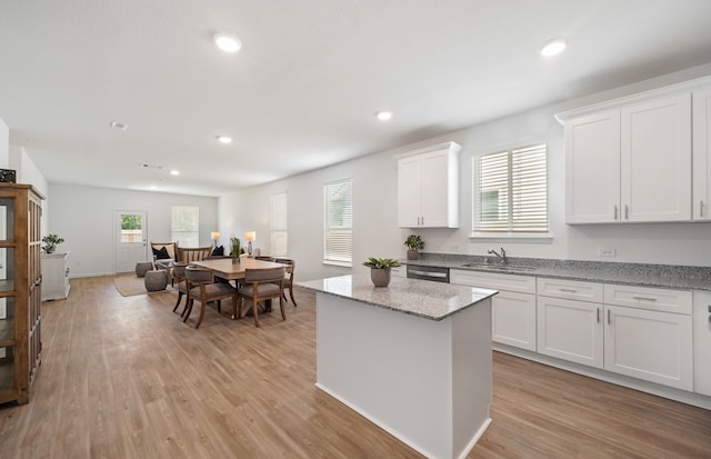 kitchen featuring light hardwood / wood-style floors, sink, white cabinetry, and a wealth of natural light