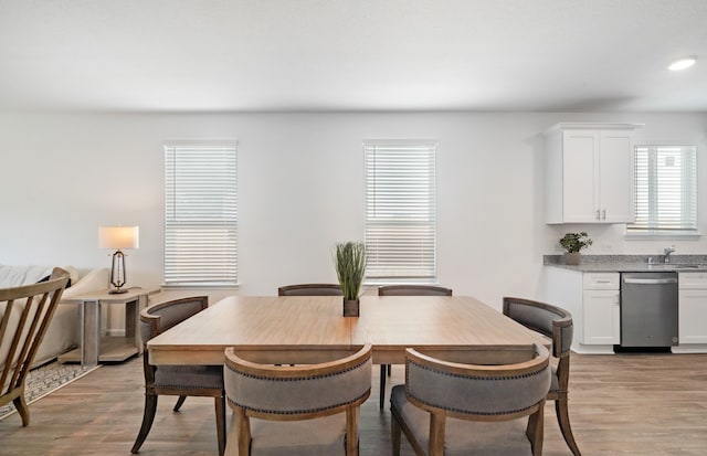 dining room featuring sink and light hardwood / wood-style flooring