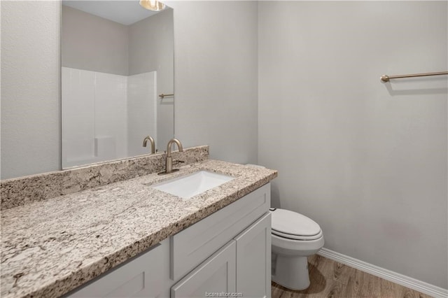 bathroom with hardwood / wood-style floors, toilet, and large vanity