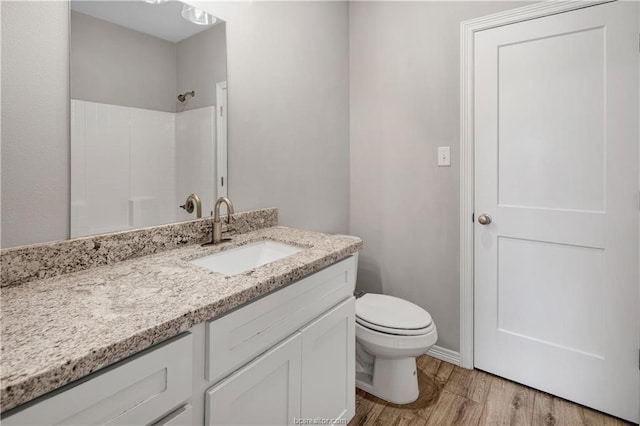 bathroom with toilet, hardwood / wood-style flooring, and large vanity