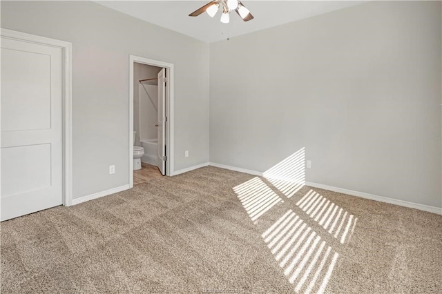 unfurnished bedroom with a closet, ensuite bath, ceiling fan, and carpet floors