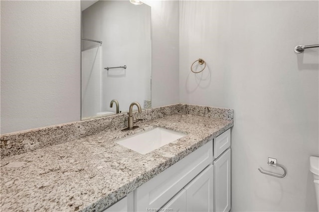 bathroom featuring vanity with extensive cabinet space and toilet