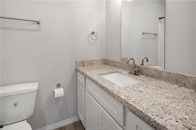 bathroom with hardwood / wood-style flooring, oversized vanity, and toilet