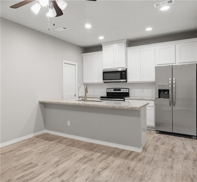 kitchen with light wood-type flooring, white cabinetry, ceiling fan, and stainless steel appliances