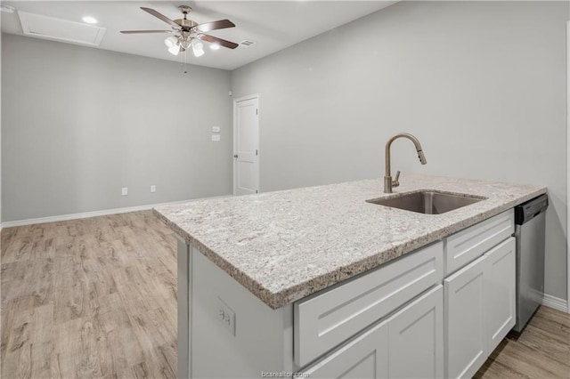 kitchen with light stone countertops, light wood-type flooring, ceiling fan, sink, and dishwasher