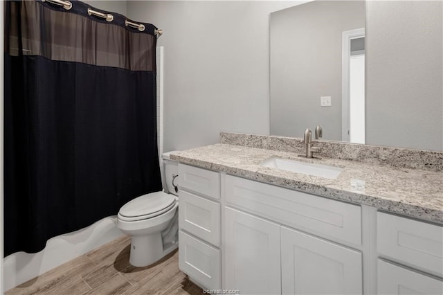 full bathroom with shower / tub combo, large vanity, toilet, and hardwood / wood-style floors