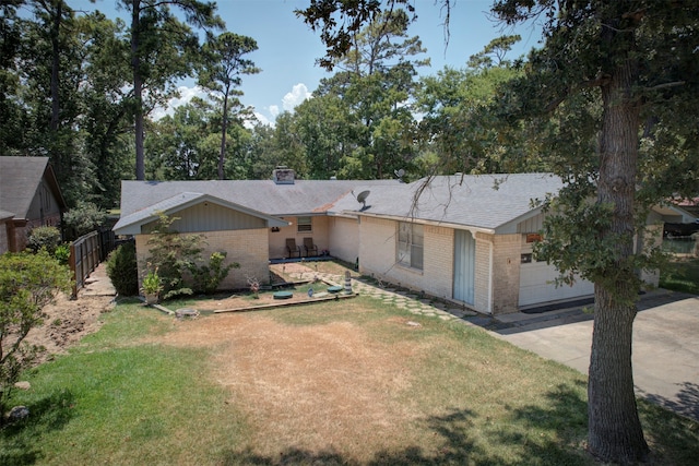 ranch-style house featuring a garage and a front lawn