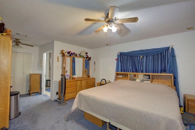 carpeted bedroom with ceiling fan and a textured ceiling