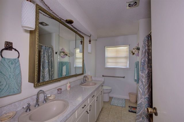 bathroom with tile floors, dual bowl vanity, a textured ceiling, and toilet