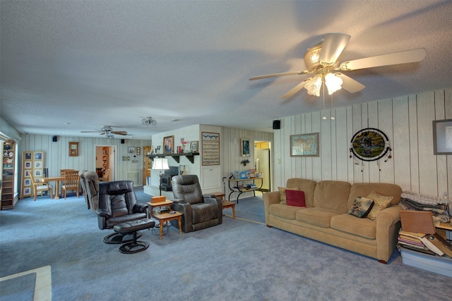 carpeted living room with ceiling fan and a textured ceiling