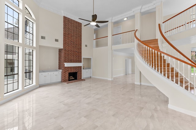 17402 Wilton Park Ct, Spring, TX 77379 - unfurnished living room featuring a brick fireplace, a high ceiling, ceiling fan, and crown molding