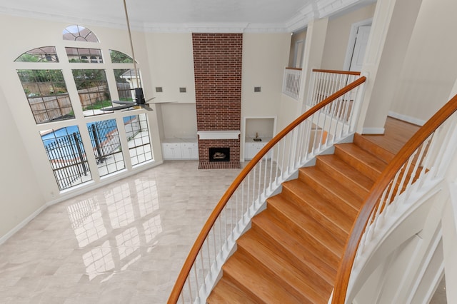 17402 Wilton Park Ct, Spring, TX 77379 - stairway with a fireplace, ceiling fan, crown molding, and brick wall