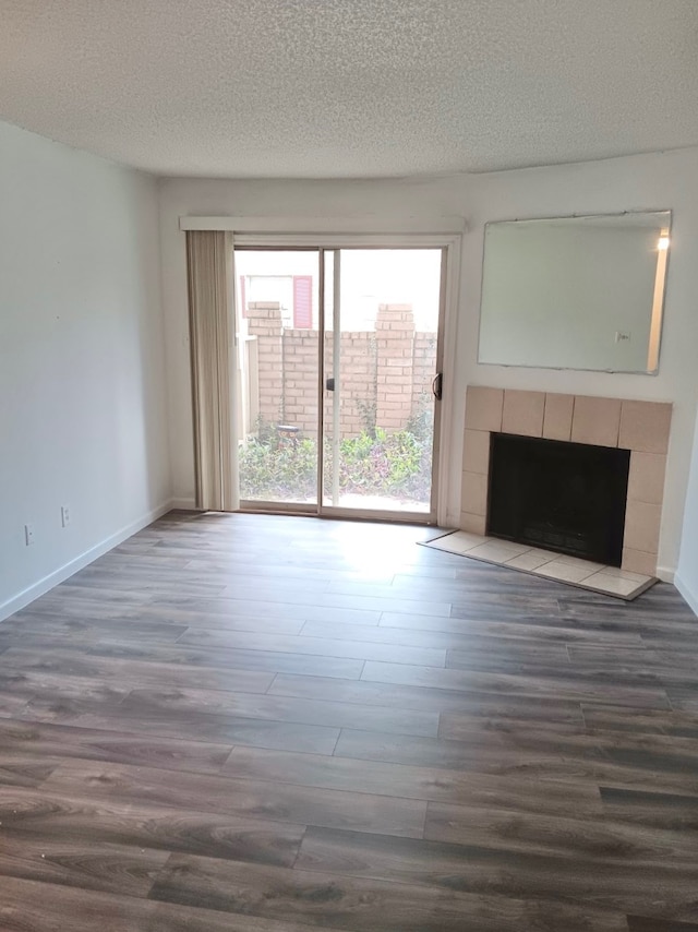 unfurnished living room featuring hardwood / wood-style flooring, a fireplace, and a textured ceiling