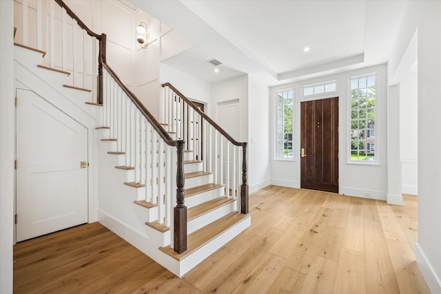 entrance foyer featuring light hardwood / wood-style flooring and a tray ceiling