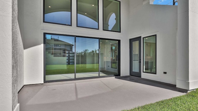 view of exterior entry with a patio