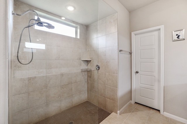 bathroom featuring tile patterned flooring and tiled shower