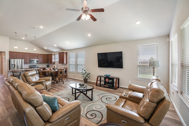 living room with light wood-type flooring, ceiling fan, and lofted ceiling