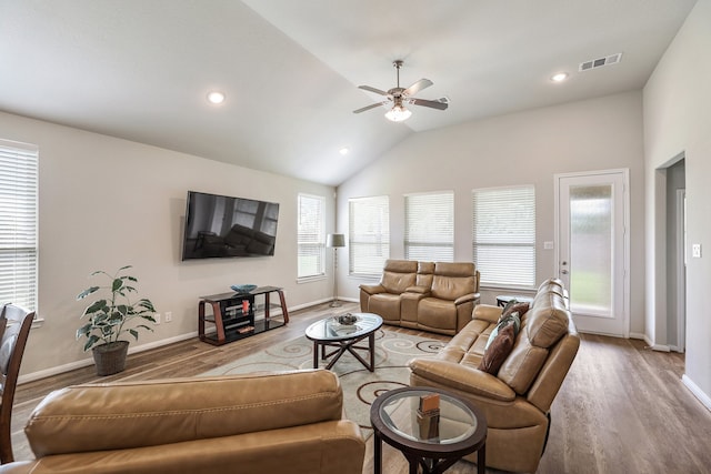 living room with wood-type flooring, a wealth of natural light, lofted ceiling, and ceiling fan