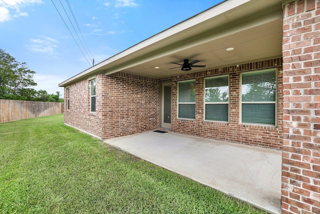 doorway to property with a yard, ceiling fan, and a patio area