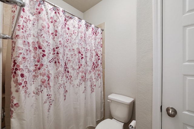 bathroom featuring walk in shower and toilet