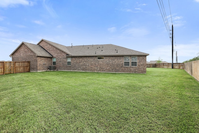 rear view of property with a lawn and central AC