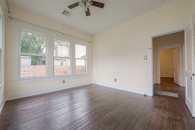 spare room with a wealth of natural light, ceiling fan, and dark hardwood / wood-style floors