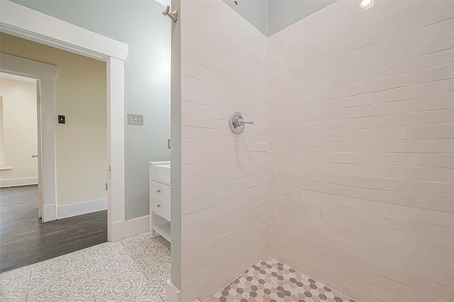 bathroom featuring vanity, a tile shower, and hardwood / wood-style floors