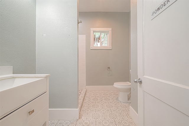 bathroom featuring vanity, toilet, tile patterned floors, and walk in shower