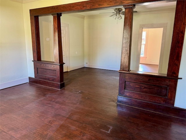 unfurnished room featuring ceiling fan, dark hardwood / wood-style flooring, crown molding, and ornate columns