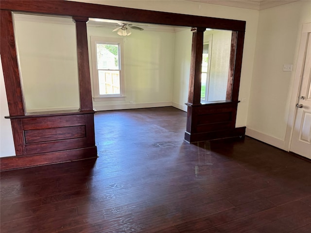 unfurnished room featuring dark hardwood / wood-style floors, ceiling fan, decorative columns, and ornamental molding