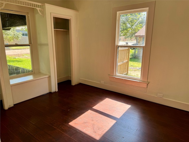 unfurnished bedroom featuring dark wood-type flooring and a closet