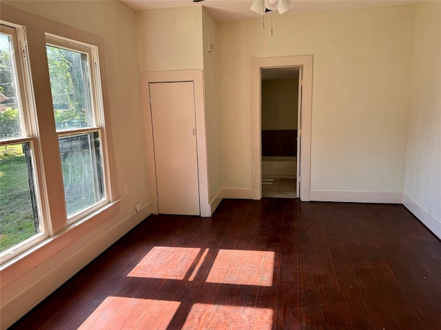 spare room with plenty of natural light, ceiling fan, and dark hardwood / wood-style floors