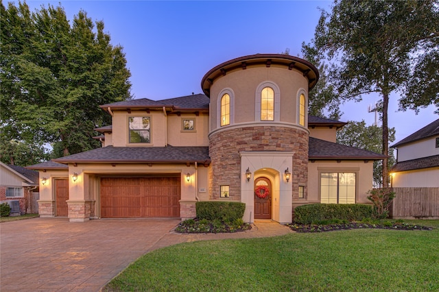 view of front of home with a garage and a lawn