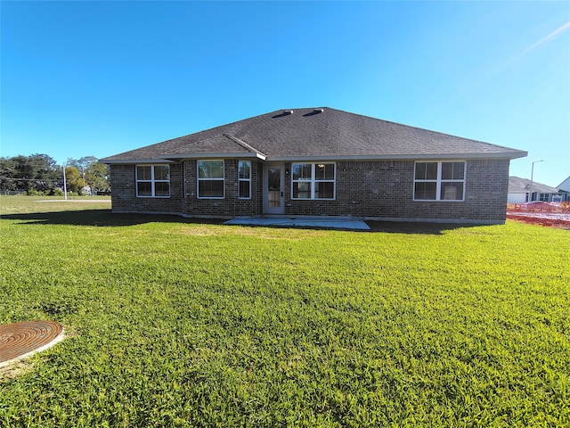 back of house featuring a lawn and a patio