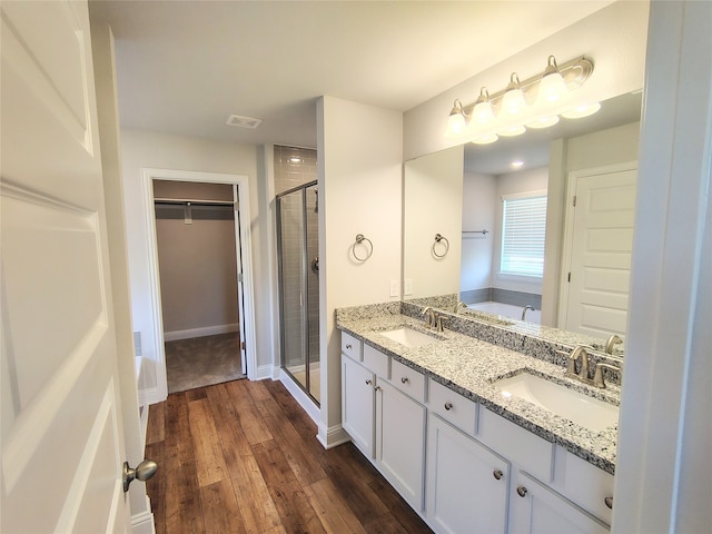 bathroom with hardwood / wood-style floors, vanity, and an enclosed shower