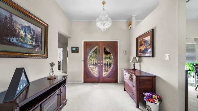 carpeted entryway with french doors, crown molding, and a chandelier