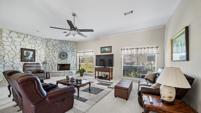 living room featuring ornamental molding, light carpet, a fireplace, and ceiling fan