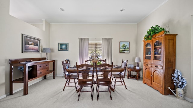 carpeted dining room with ornamental molding