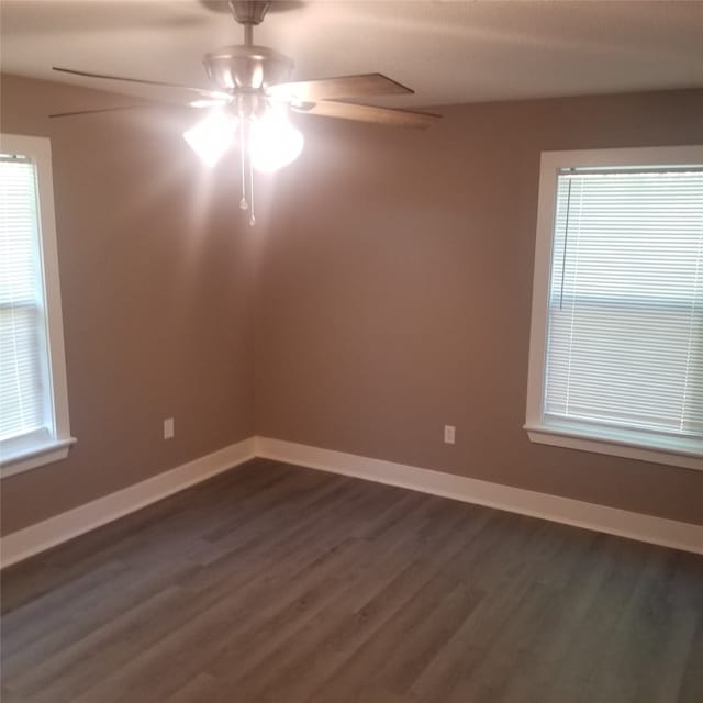 unfurnished room with ceiling fan and dark hardwood / wood-style flooring