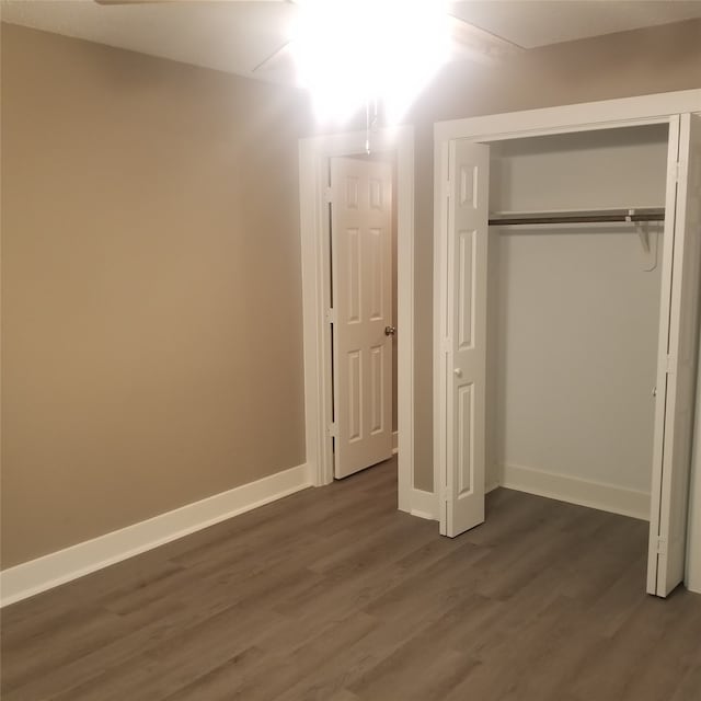 unfurnished bedroom featuring a closet and dark hardwood / wood-style flooring