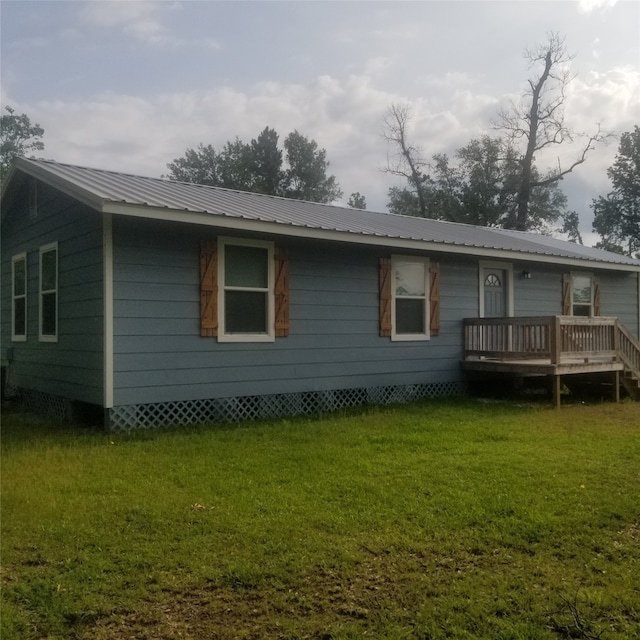 view of front of property featuring a front yard and a deck