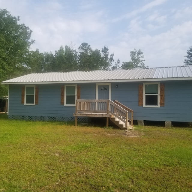 rear view of house featuring a yard