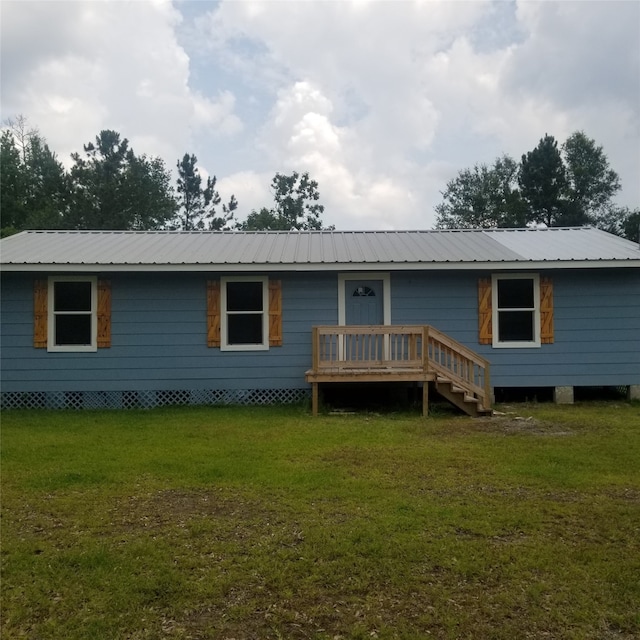 back of property with a wooden deck and a yard