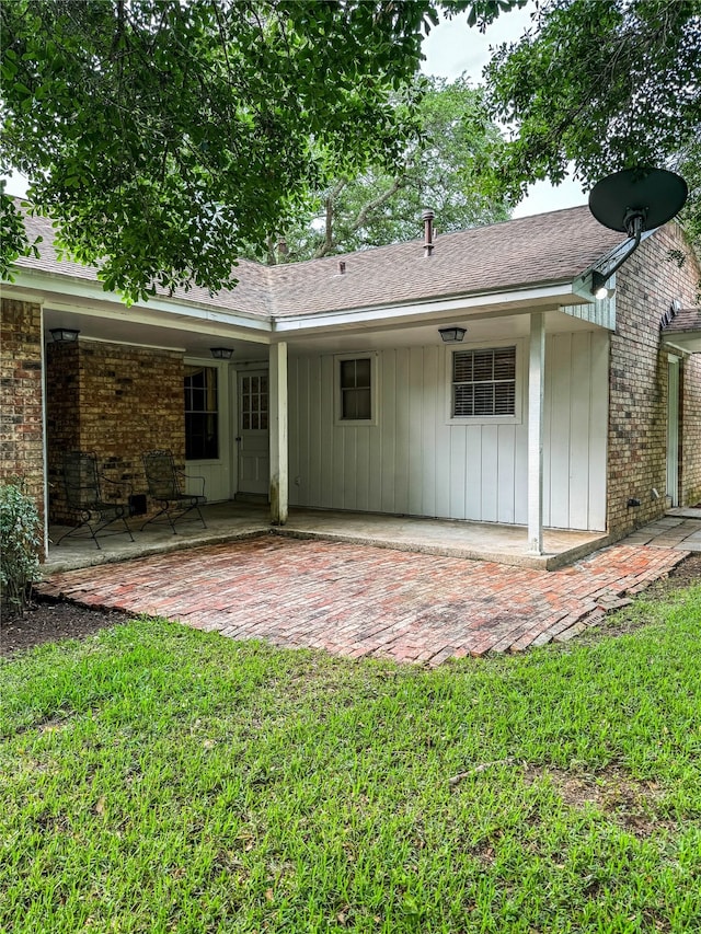 rear view of property featuring a yard and a patio