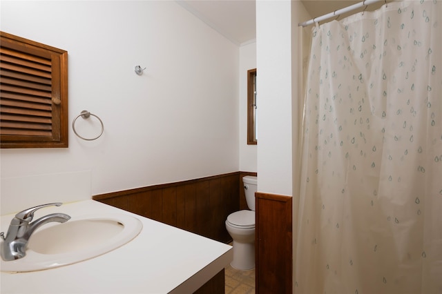 bathroom featuring curtained shower, wood walls, toilet, and vanity