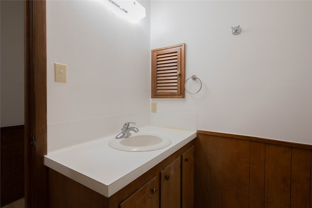 bathroom featuring wood walls and vanity