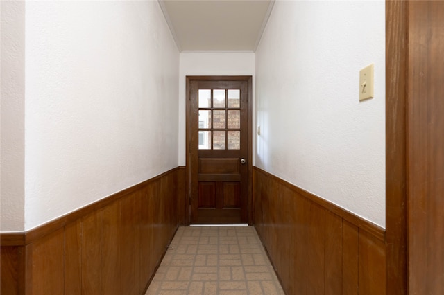 entryway featuring wood walls and ornamental molding