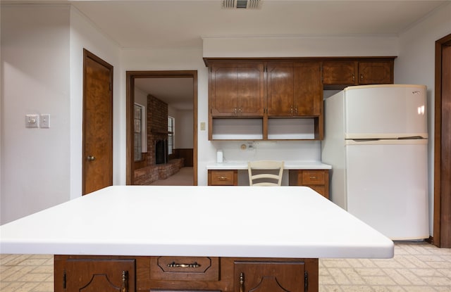 kitchen featuring a brick fireplace and white fridge