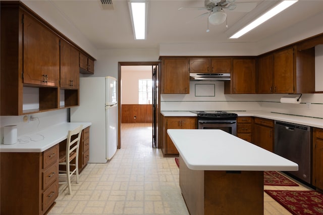 kitchen with appliances with stainless steel finishes, wooden walls, and ceiling fan