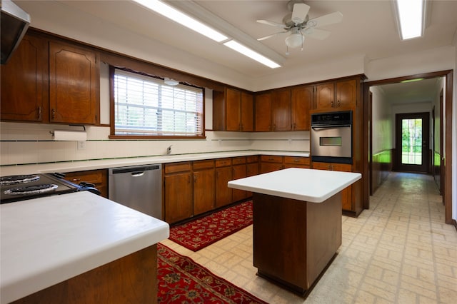 kitchen featuring stainless steel appliances, ceiling fan, a center island, and a healthy amount of sunlight